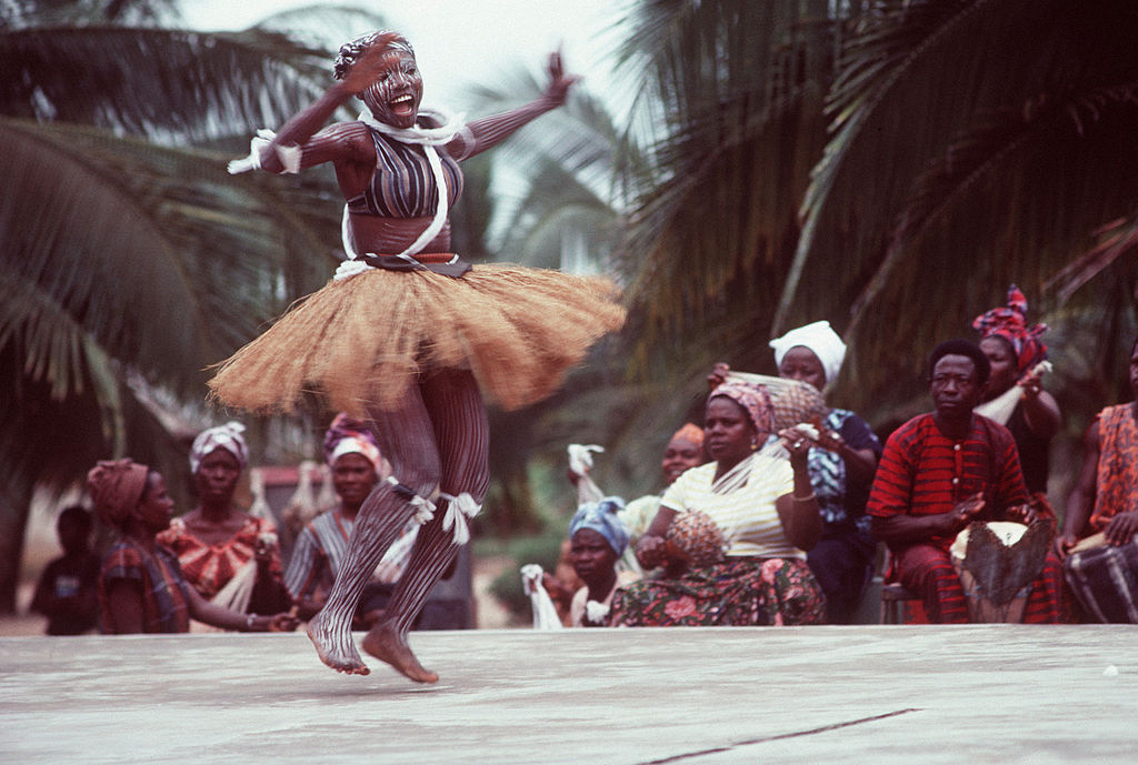An African woman, wearing native garments, performs during a visit from participants in the West Africa Training Cruise. April 1984. All hands Magazine. Public Domain.